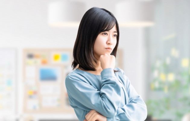 女性がおかしいと感じながら考える様子の写真