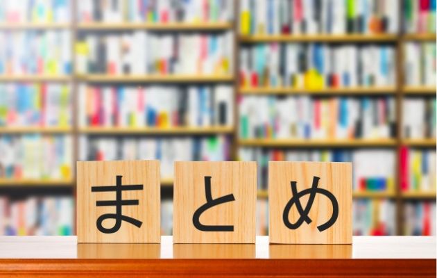 背景の本棚はぼやかしてあり、手前のテーブルに木のブロックで「まとめ」と書いてある写真