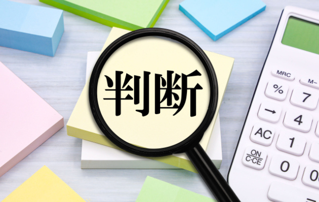 正方形の付箋が何色か置いてあり、黄色の付箋に「判断」と書かれている。判断の文字を虫眼鏡で文字が見えるようになっている写真