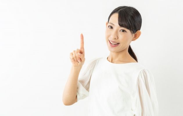 女性が人差し指をだして、見直し方を説明しようとしている様子の写真